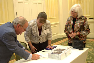 People signing in at a meeting registration table