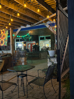 Outdoor patio with string lights and tables at night