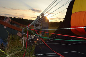 People preparing a hot air balloon at sunset