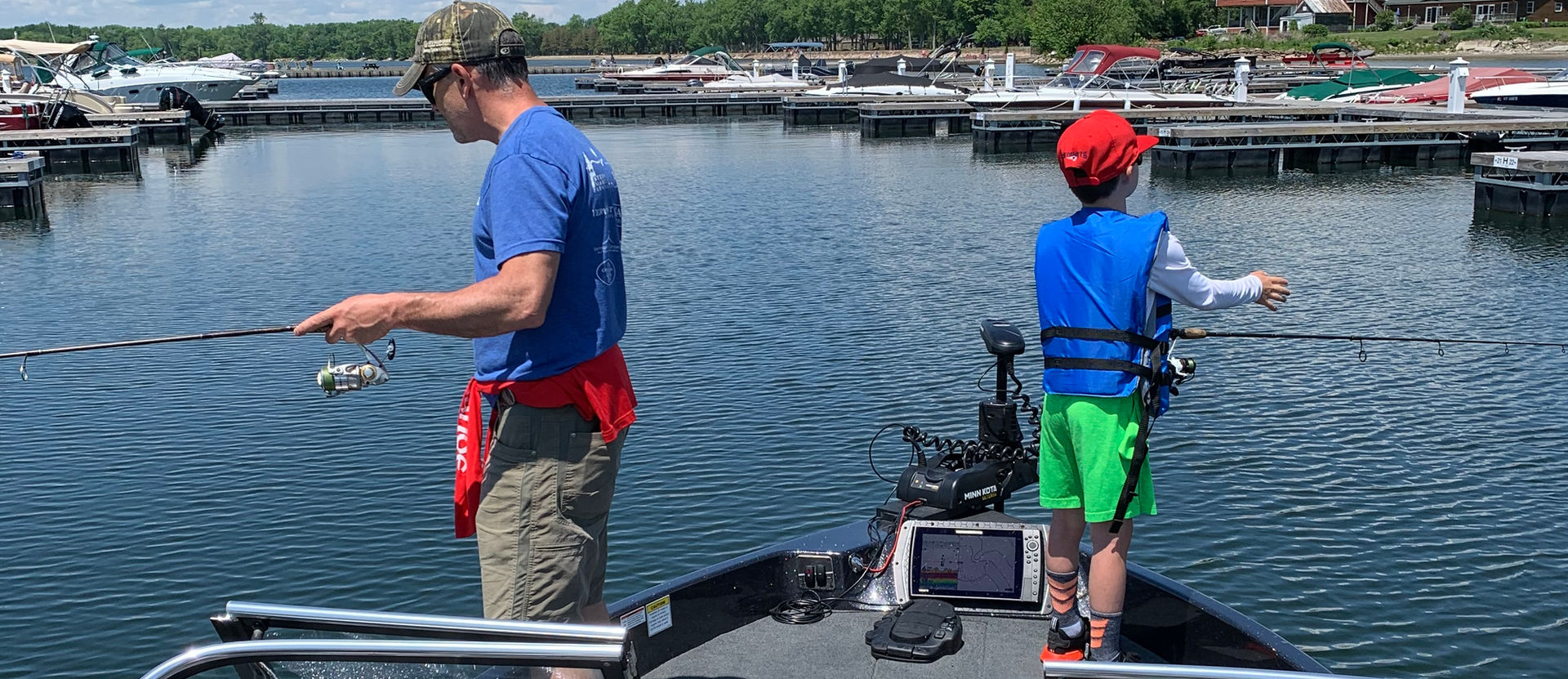 Father and son fishing together on a boat in the lake
