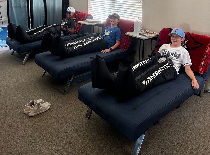 Young athletes relaxing with Normatec recovery boots
