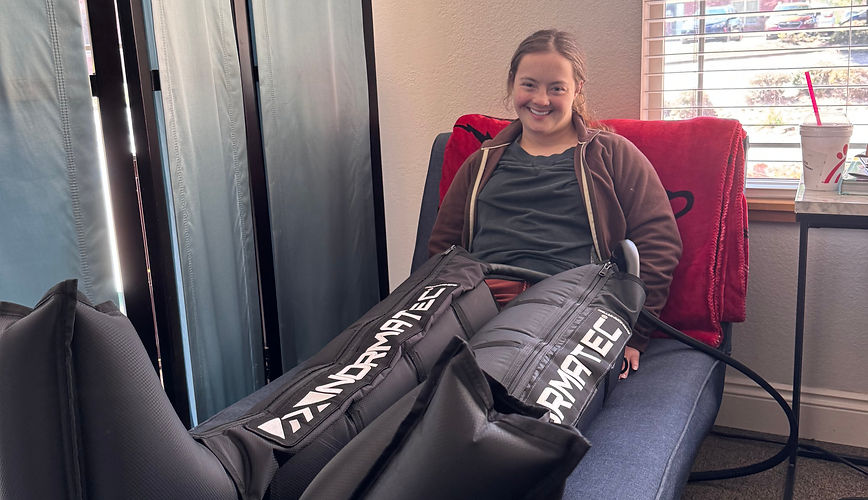 Woman smiling during NormaTec compression therapy