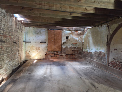 Old room with wooden ceiling beams and decaying walls
