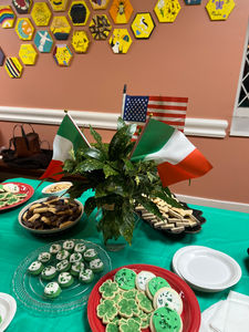 Dessert table with Italian and American flags, various cookies.