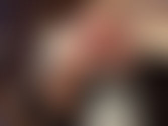 Woman with grey hair kisses smiling man's cheek affectionately.