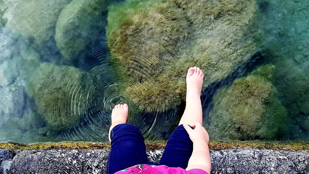 Child dipping toe in water