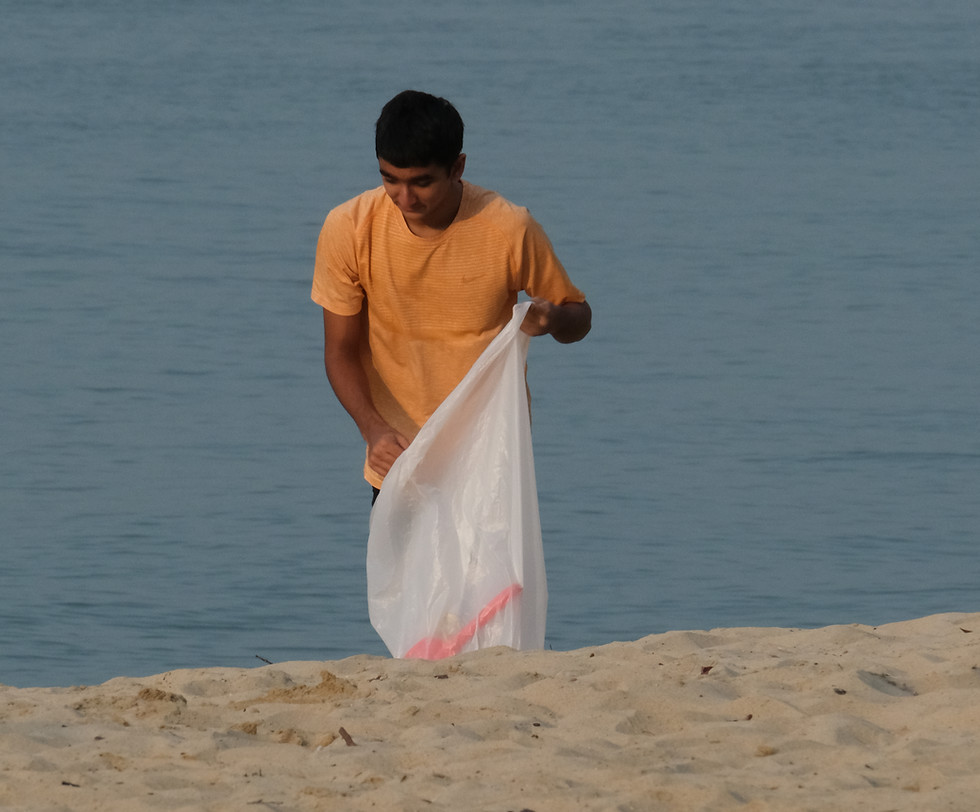 Man cleaning a sandy beach