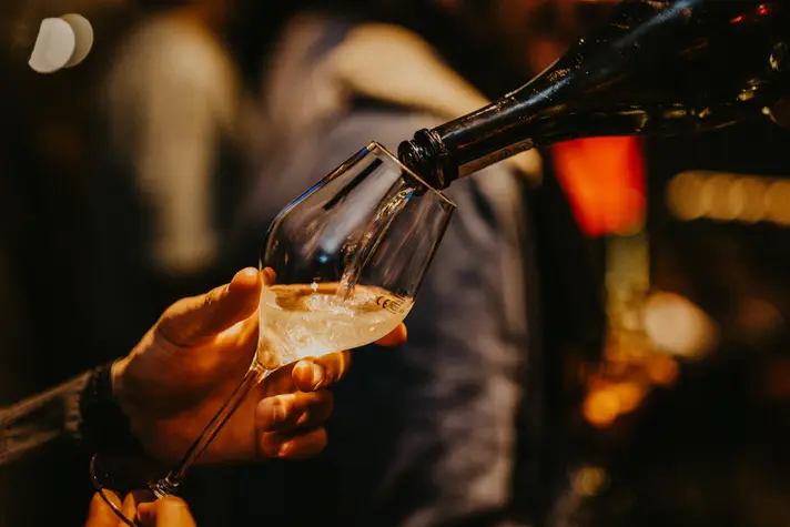Abendaufnahmen Barkeeper füllt stilvoll den Weinglas auf - Veranstaltung Fotografie; emotionale Nachtfotografie eines stilvollen Moments in einer Berliner Bar.