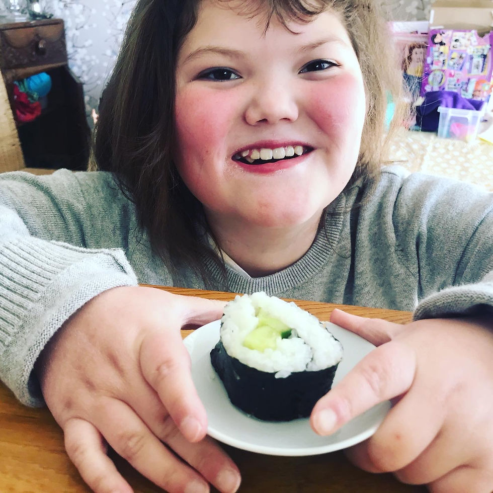 Girl smiling with sushi on a plate