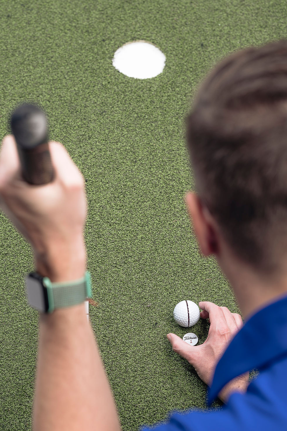 golfista ustawia linię na piłce do puttowania