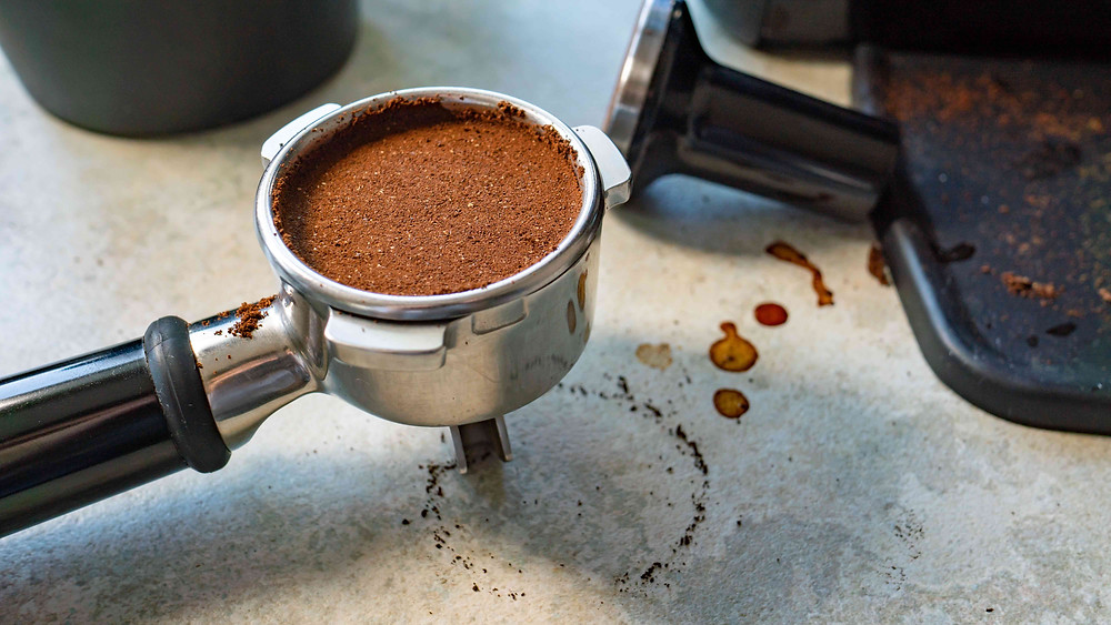 Freshly ground tamped compressed coffee in portafilter