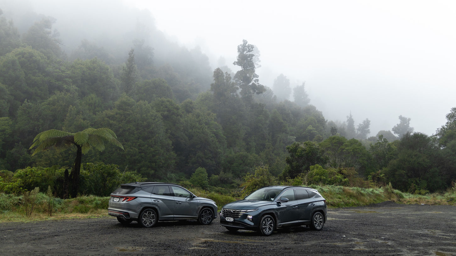 Two 2021 Hyundai Tucson vehicles parked by foggy forest, near New Plymouth, New Zealand