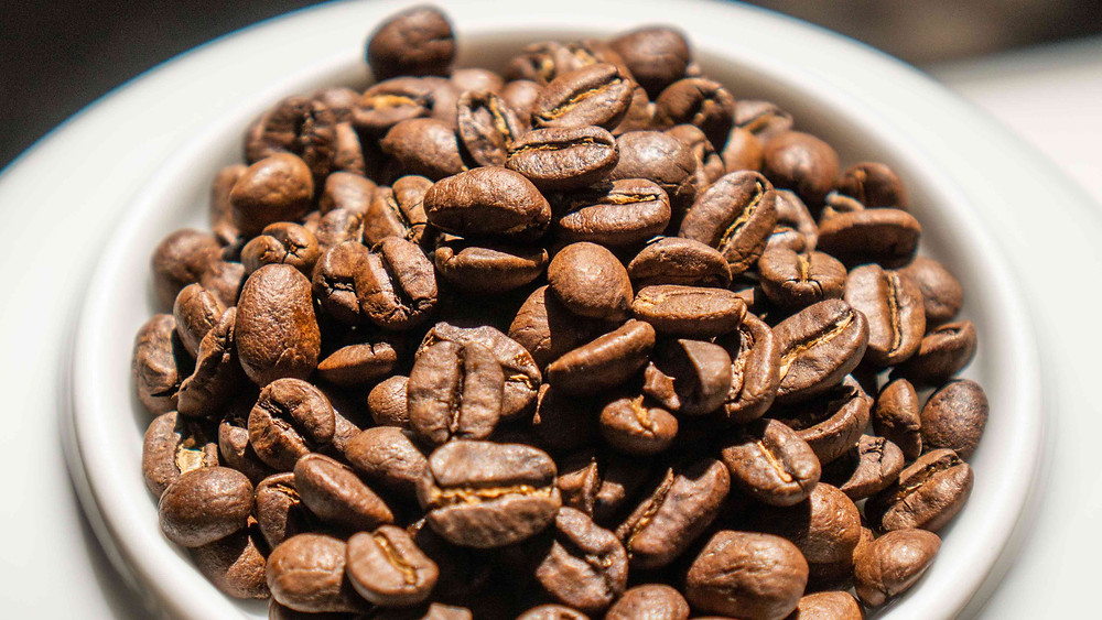 Medium roasted whole coffee beans on plate