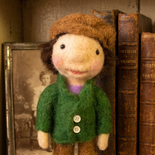 Felted Boy Doll wearing a green jacket brown trousers and hat.