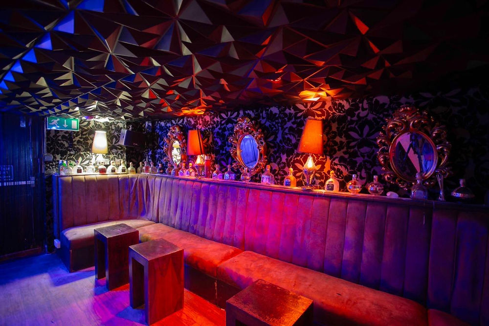 Stylish private venue with velvet seating and mirrors.