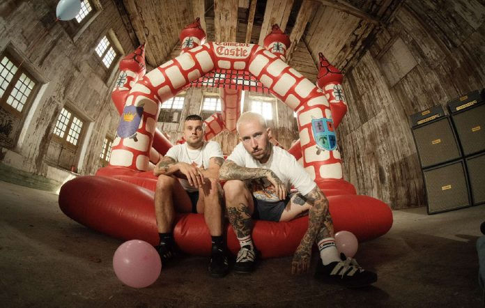 Soft Play sitting on a bouncy castle as part of their new music video for their comeback anthem 'Punk's Dead'
