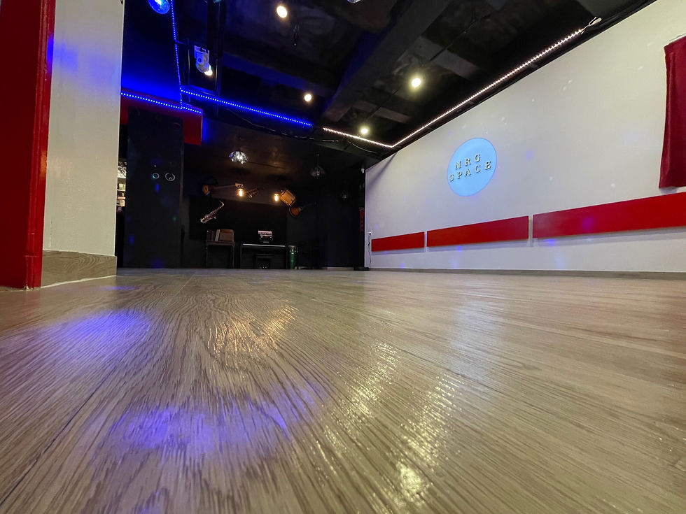 Eye-level view of a tango studio with wooden floors and NRG SPACE beautiful logo
