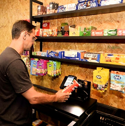 homem passando compras no mini mercado morada market