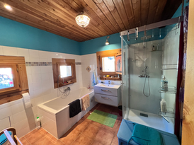 Salle de bains avec baignoire et douche dans le gîte
