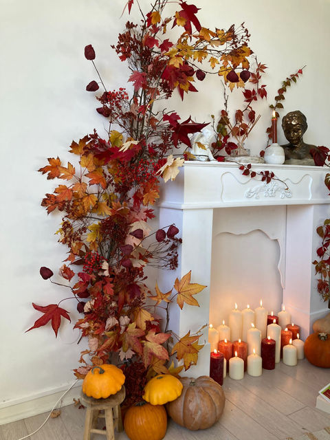 decoration cocooning automnale cheminee illuminee bougies une arche de feuille automne orange et jaune avec potimaron citrouille butternut