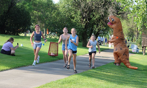 Girls running by T Rex.JPG