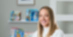 Dr. Tracy Kirk smiling in front of shelves of children's books