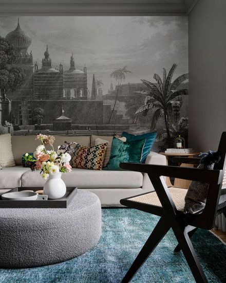 Indian palace wallpaper mural sectional sofa round grey ottoman, black cane chair