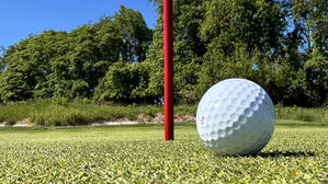 balle de golf devant un trou