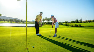 Deux amateurs de golf faisant un putt