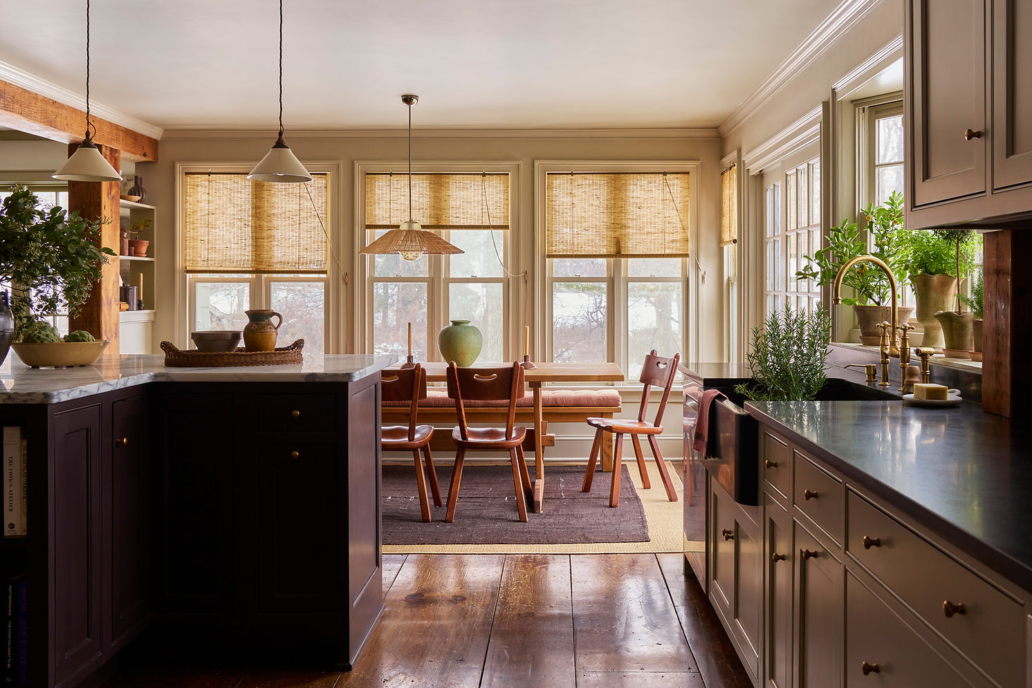 Dining room with natural wood table, pendant lighting, and collected decorative objects.