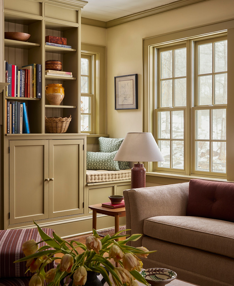 Styled living room vignette with bench seating, ceramic lamp, and decorative objects.