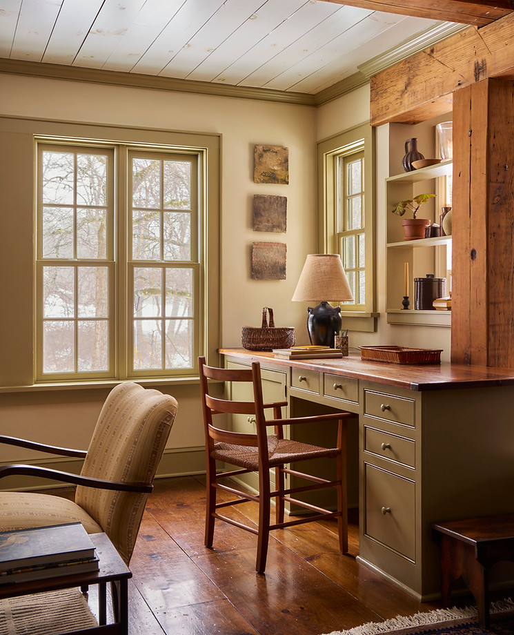Layered built-in desk in a Ridgefield, Connecticut home with vintage furniture, artwork, and natural light.