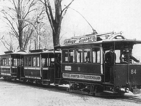 Eine alte Straßenbahn mit zwei Anhängern.