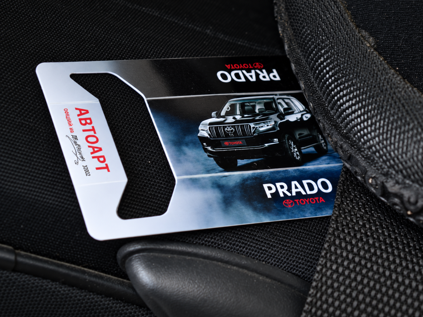 Real Toyota Prado Autoart HOLDERCARD promotional card on a vehicle seat