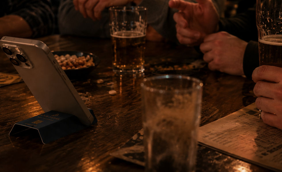 Personas fijándose en un producto promocional de marca inusual junto a un smartphone durante una conversación