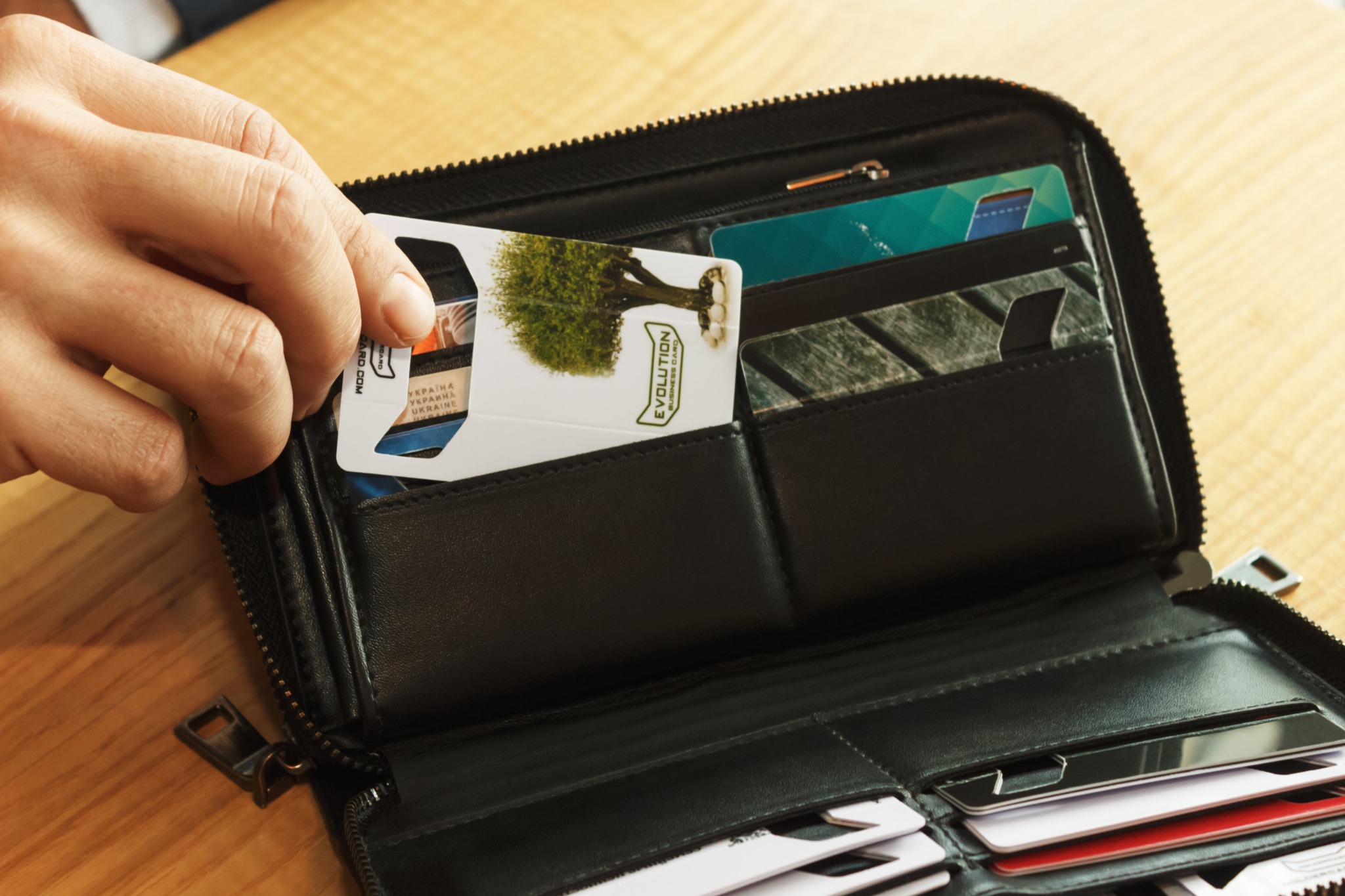 Original photograph of a wallet-size branded HOLDERCARD being taken out of a wallet