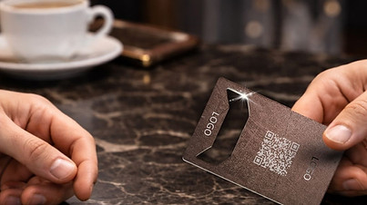 Branded Holdercard being passed from one person to another across a café table.