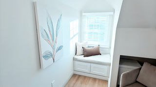 Cognitive Spatial Alignment: A close-up of a window seat overlooking nature, designed to pull the exterior environment into the private sanctuary of the home.