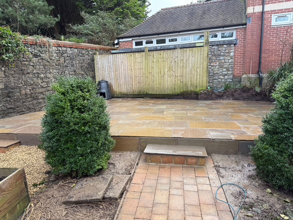 a brick walkway with a wooden fence in the background