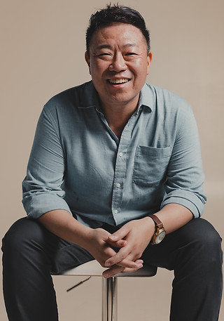 Portrait of Dr. Glen Hong seated on a chair