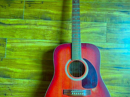 A Green Guitar Case and a Pocket Full of Cash at a Bus Stop in Texas by Rosemary Porto
