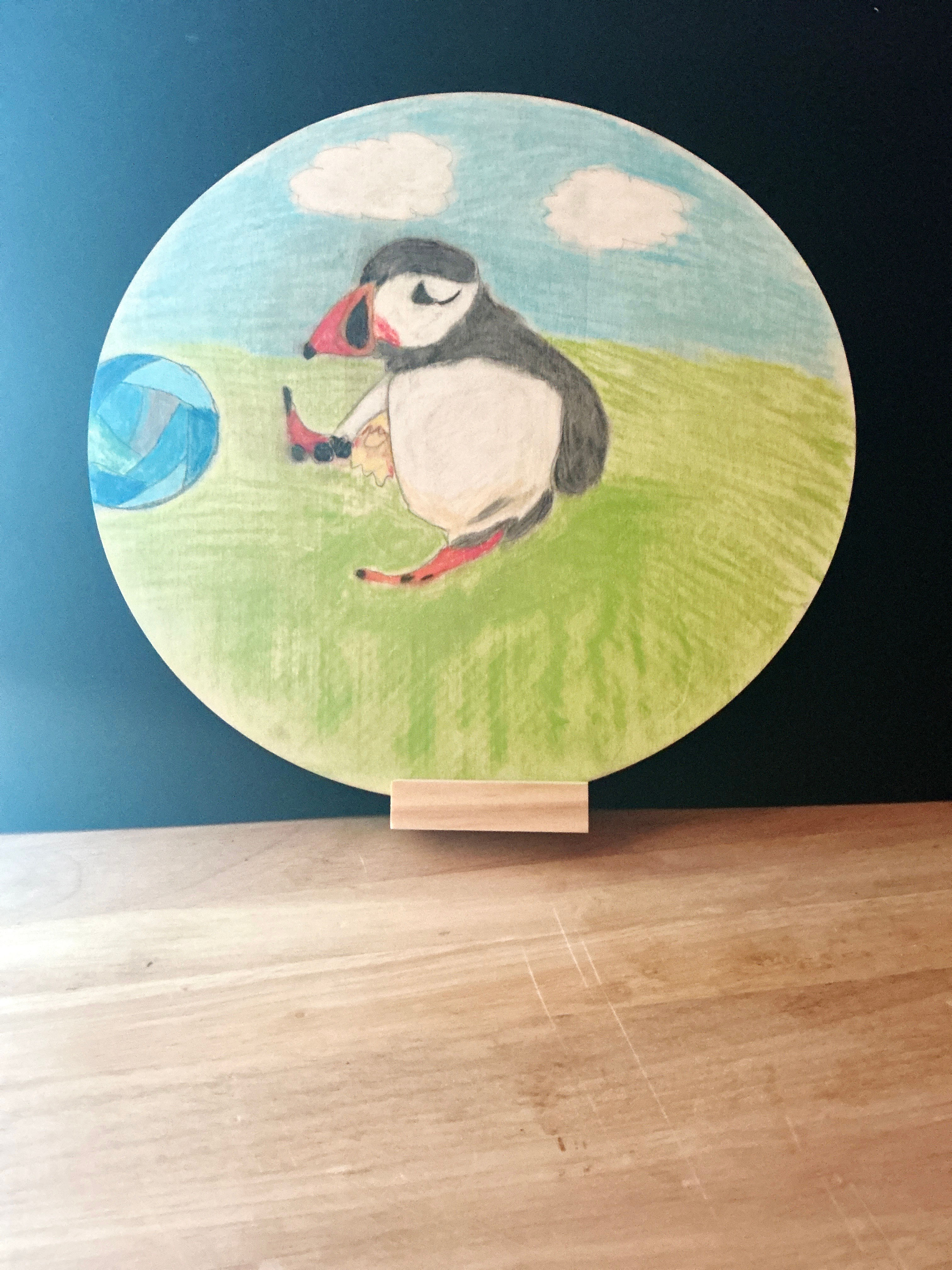 Ein Papageitaucher aus Pastellfarben auf eine Holzplatte gemalt