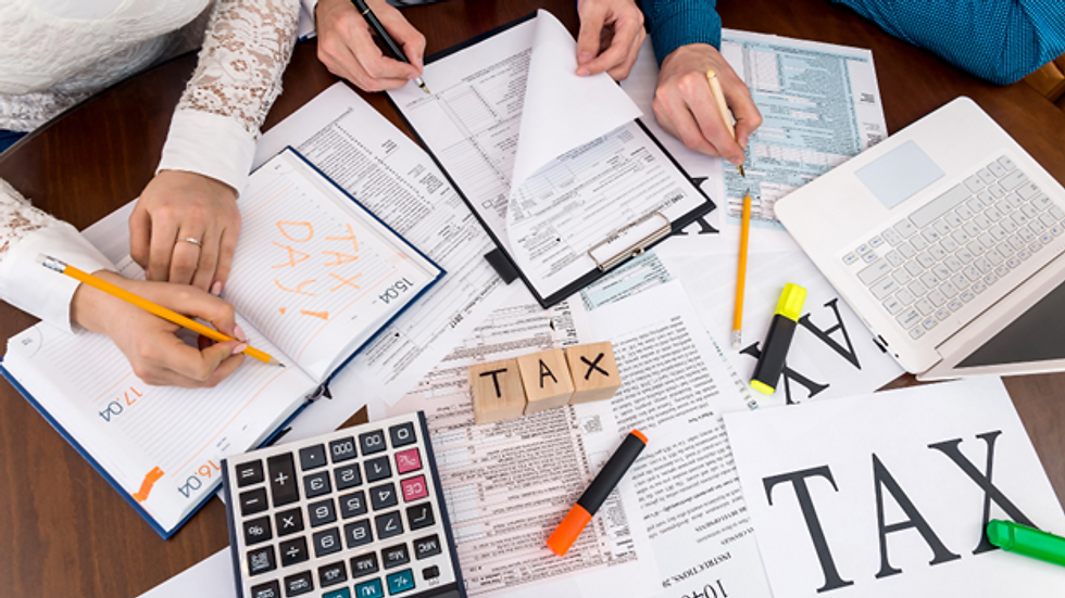 Close-up view of a person filling out a tax refund form with a pen