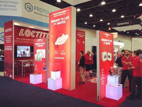 Henkel Loctite booth at Formnext — stand com displays vermelhos iluminados.