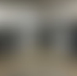 Impressora 3D industrial Stratasys parada em galpão com cobertura de proteção.