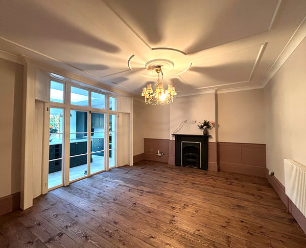 Large back room with original French doors with shutters, and ceiling rose. Fireplace, panelling and chunky skirting.