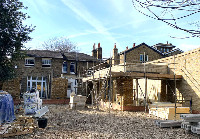 Brick extensions being built at the back of the Georgian house.