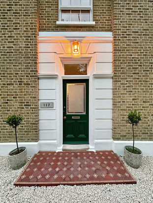  Green front door for an environmentally green  house. With reclaimed floor tiles on the step.