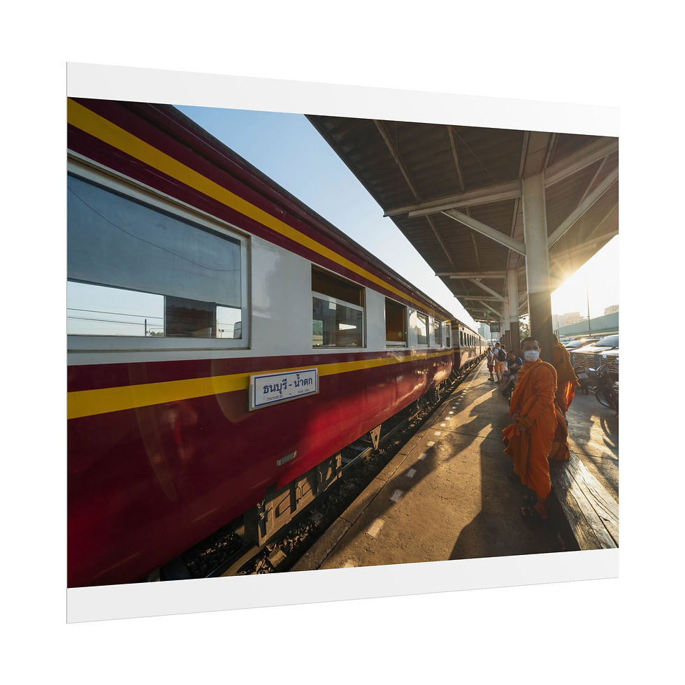 Thumbnail: Orange-robed monk walks beside red train at sunny station platform.