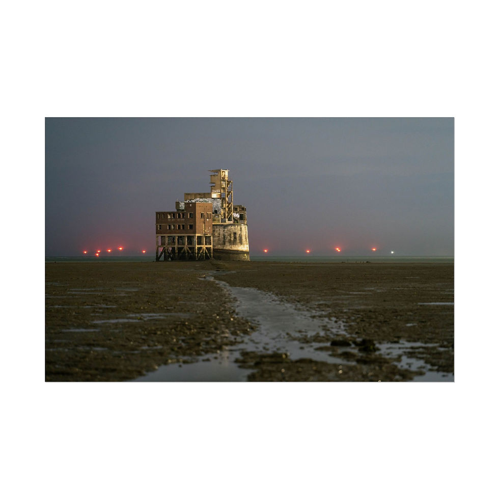 Thumbnail: Grain Tower in Kent at night with distant red lights.